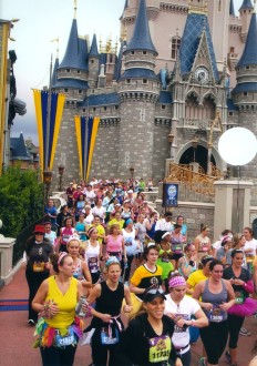 Aurora running in a huge crowd of people by the castle in the Disney Princess 2012 half marathon