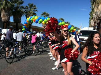 Cheerleaders cheering by a big balloon banner at the Tour de Palm Springs 2012