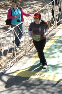 Aurora running by the gate leading people into the finish of Rock 'n' Roll New Orleans half marathon 2012