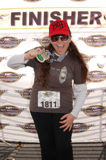 Aurora De Lucia smiling in the finisher area with her huge North Carolina half marathon medal 2012