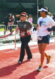 runners Joe and Aurora on the red carpet finish of the Hollywood Half Marathon 2012, smiling a bit while coming in