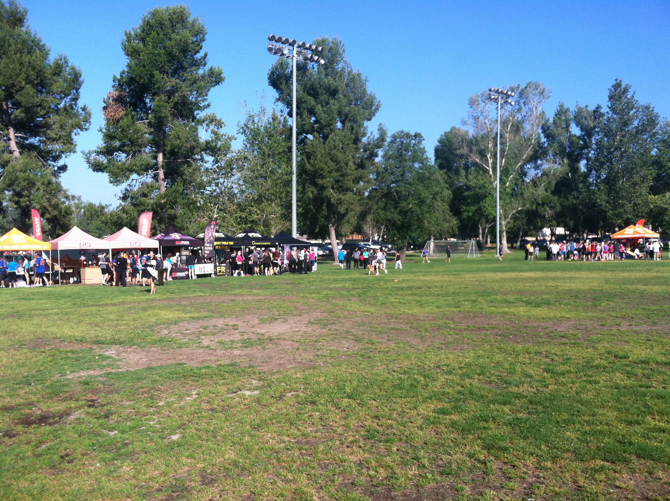 big field with runners and volunteers at booths in Anaheim at Exchange 6 during Ragnar 2012