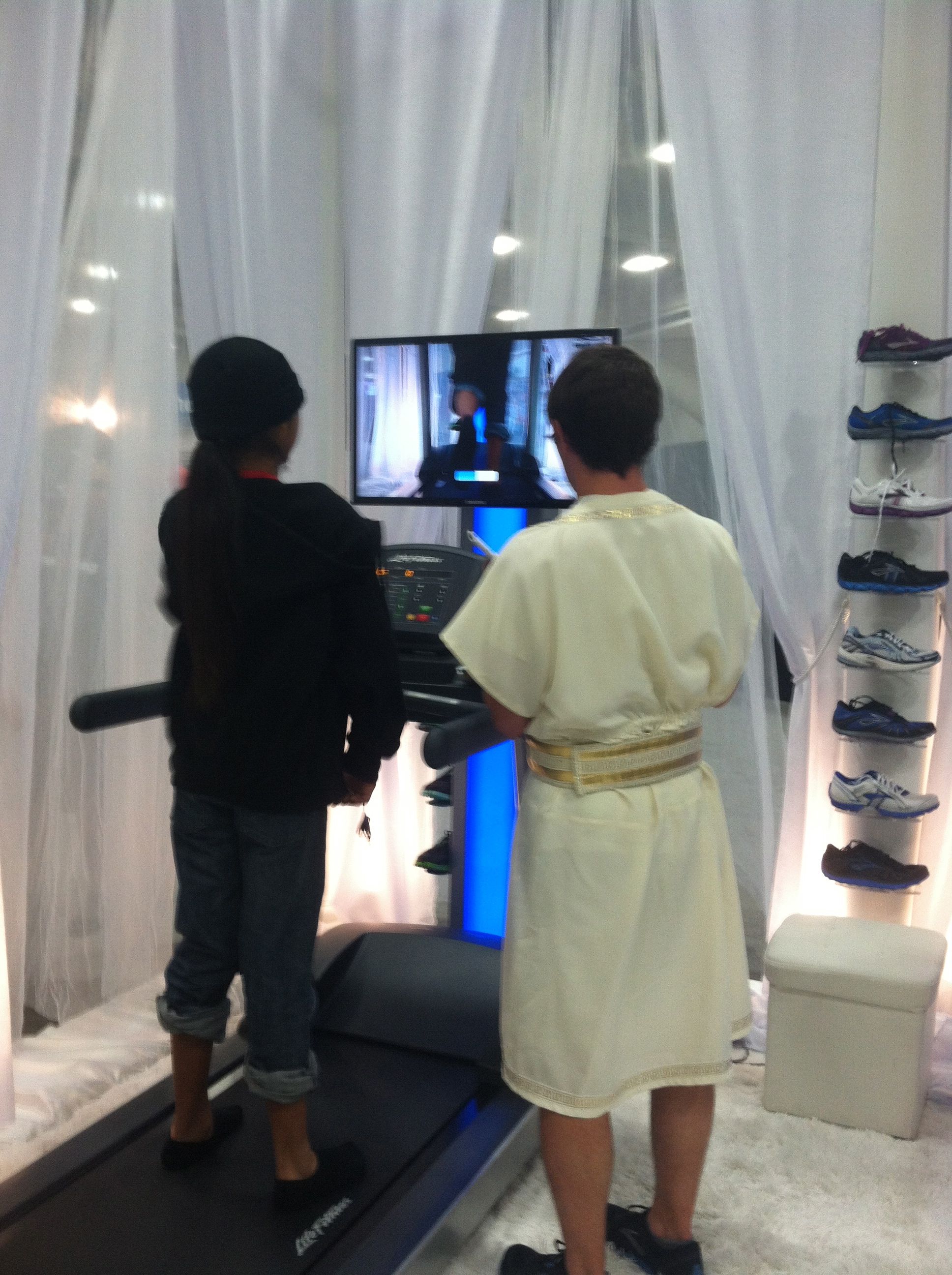 an unexpected friend from high school in a toga evaluating someone's form at the Brooks heaven display at the Rock n Roll San Diego marathon expo booth 2012