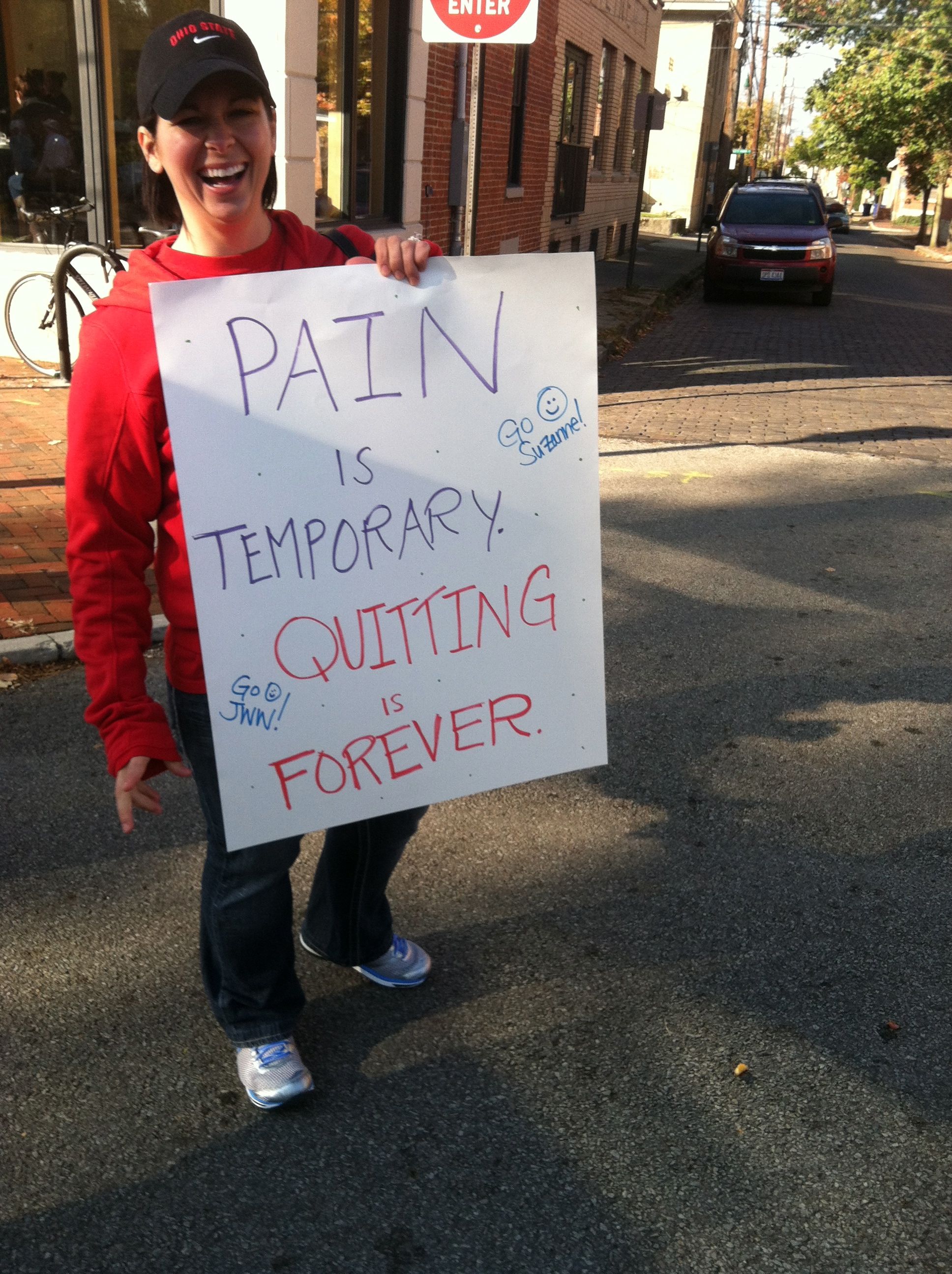 a spectator at the Nationwide Children's Hospital Columbus Half Marathon 2012 holding a sign that says "Pain is temporary, quitting is forever"