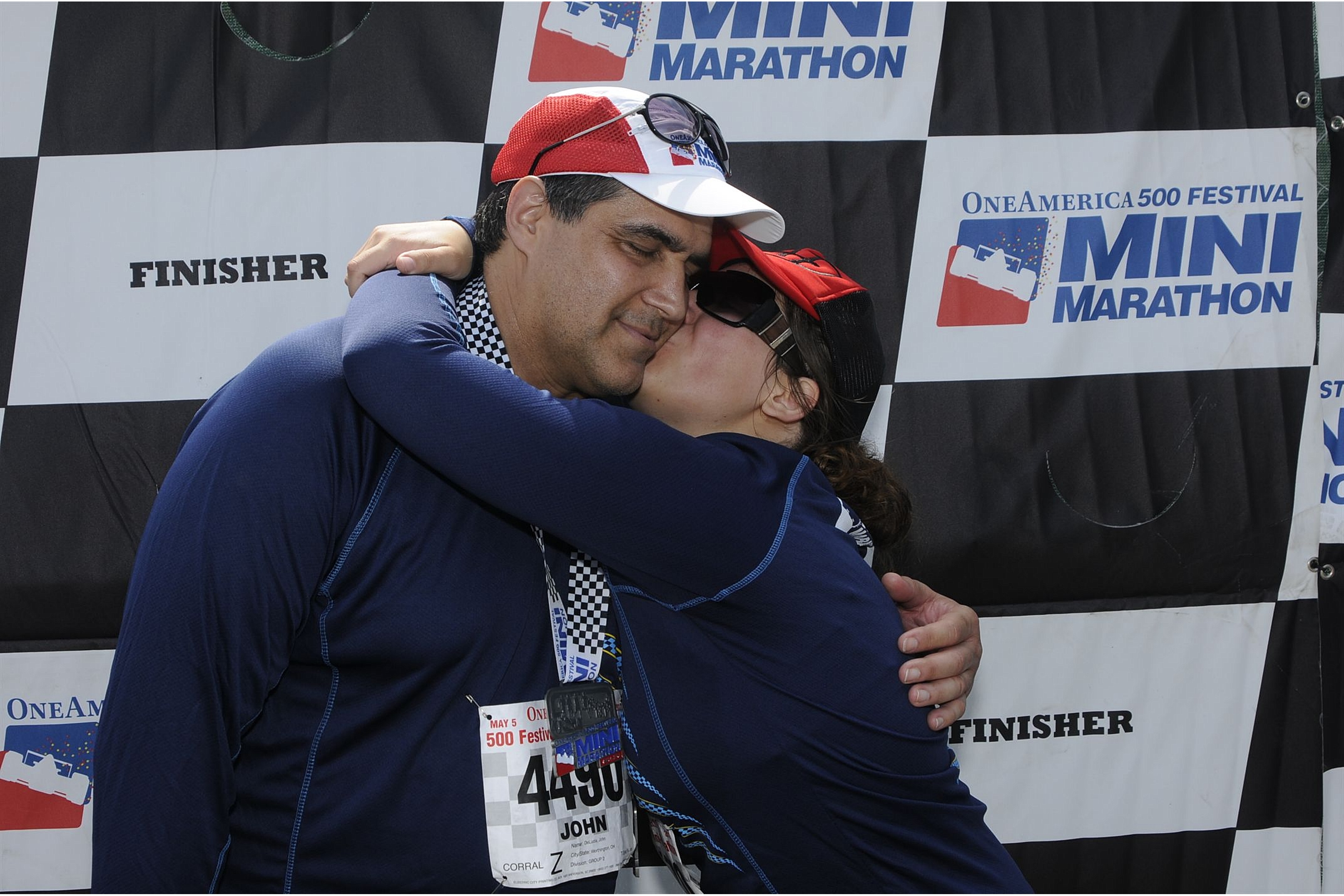 Aurora De Lucia kissing her dad on the cheek after his first half marathon at the Indianapolis 500 Festival