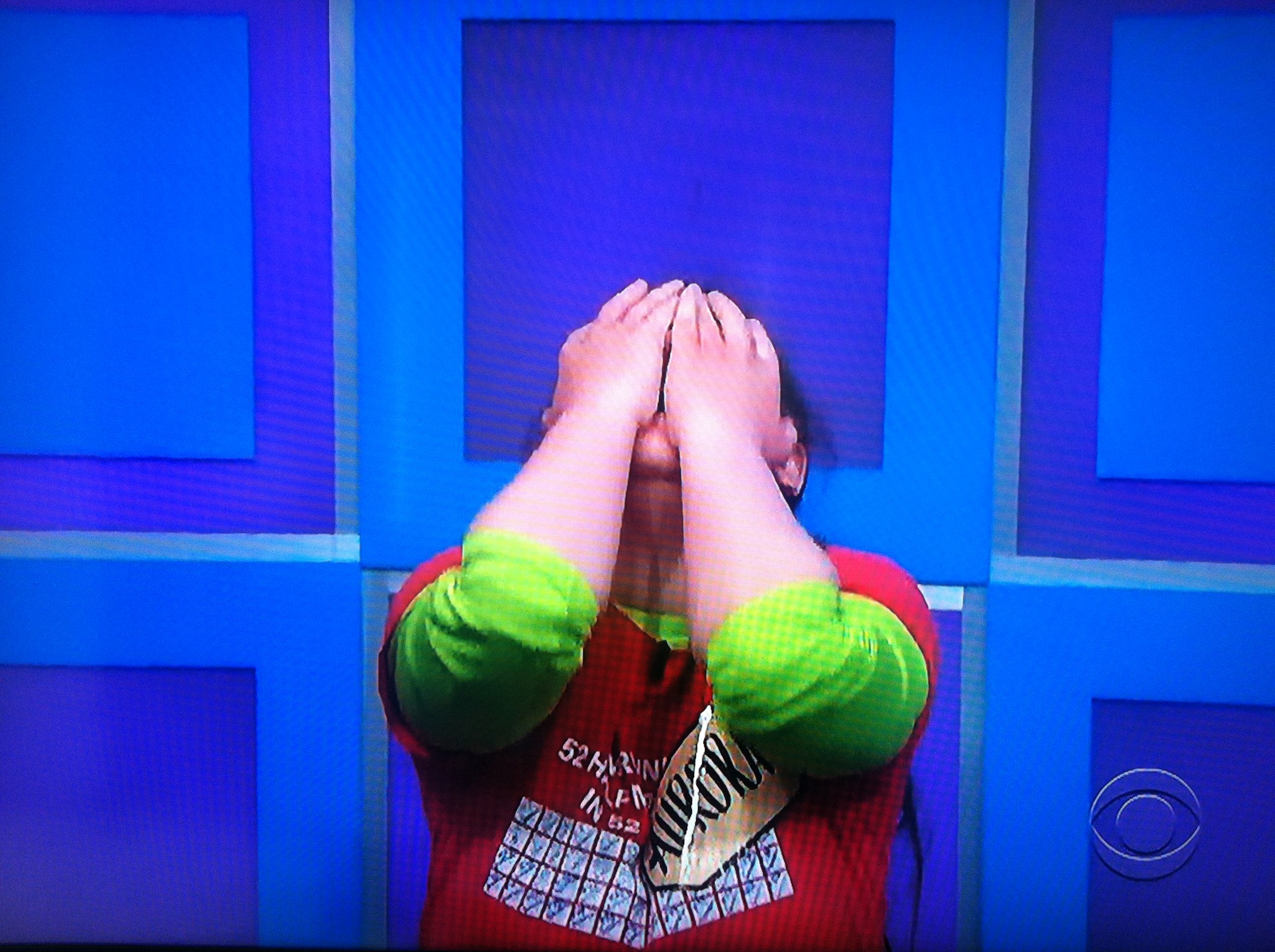 Aurora De Lucia kneeling down with her hands over her face after she learns she's playing for a brand new car on The Price is Right