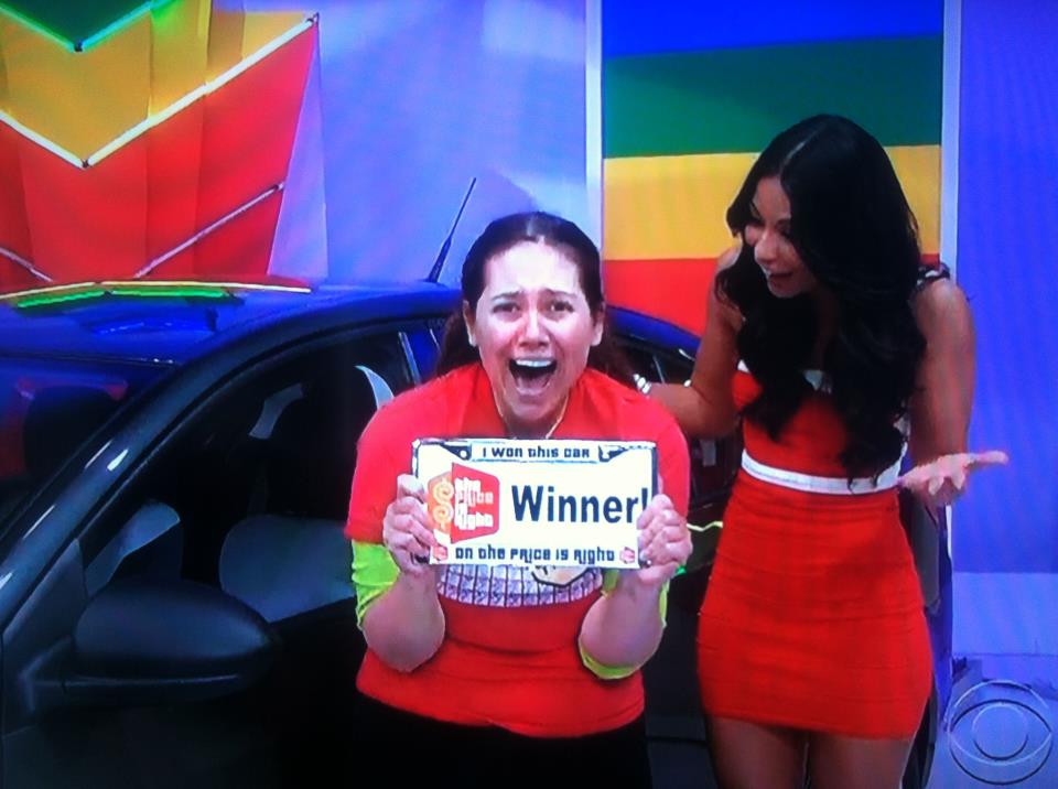 Aurora De Lucia holding her "winner" license plate after she won the car on The Price is Right