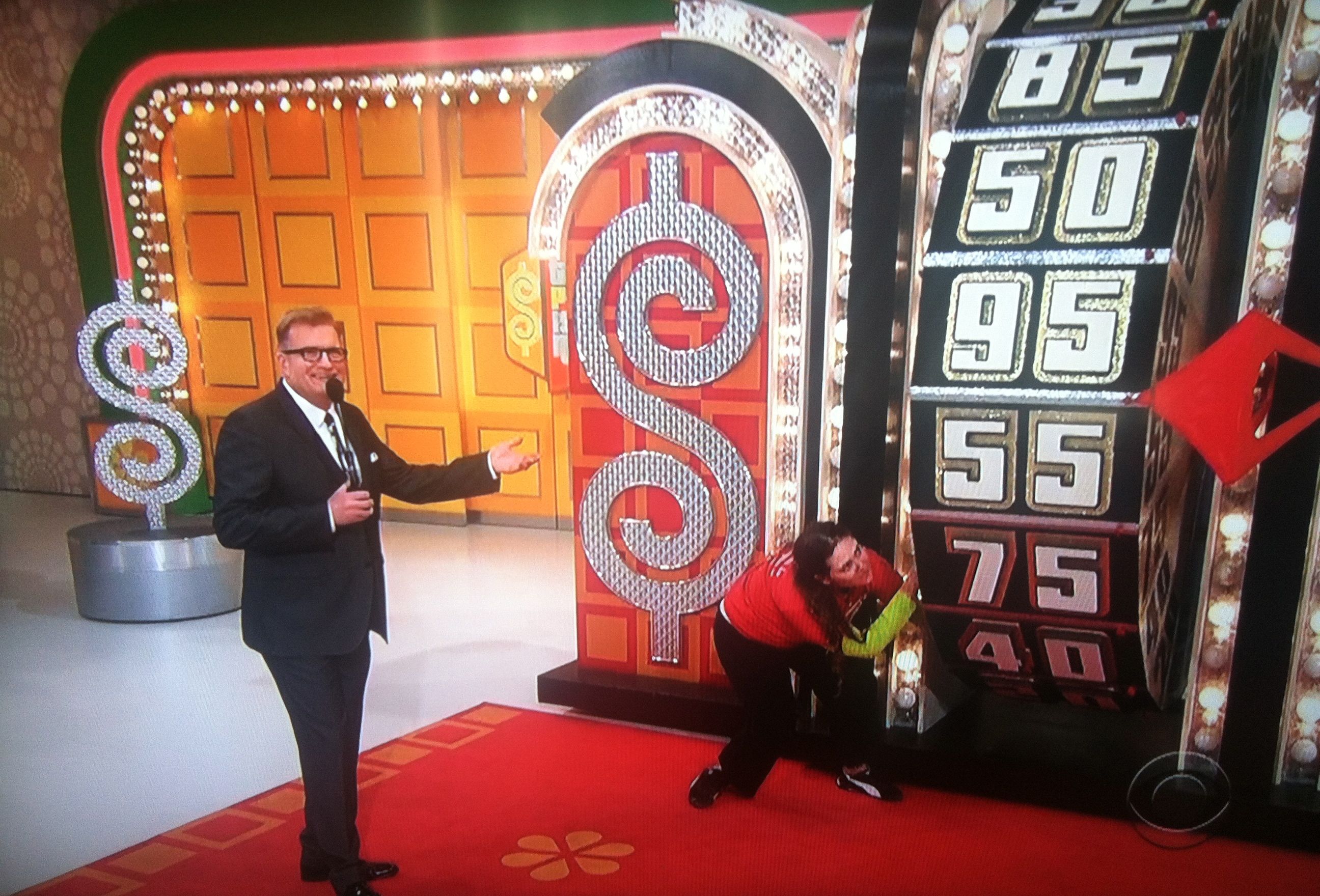 Aurora De Lucia down low, getting momentum on The Price is Right wheel as Drew Carey talks.