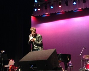 Eric McCormack sweetly singing on stage right during his concert.