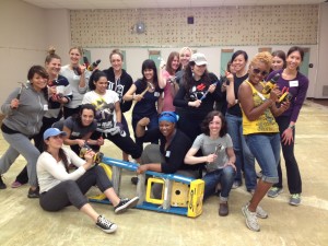 Aurora and other women from the Do Good Bus making a "who's bad" face while holding their tools