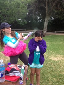Aurora De Lucia spraying the hair of a little girl before the Girls on the Run 5k