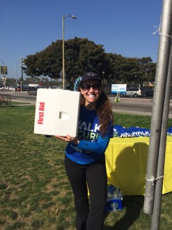 Aurora giving a large smile with the first aid kit by her face at the Walk for Arthritis