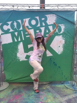 Aurora De Lucia posing in front of the Color Me Rad sign after the race 