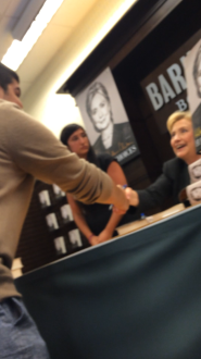 Hillary Clinton shaking hands with a fan at her book signing in Los Angeles, CA