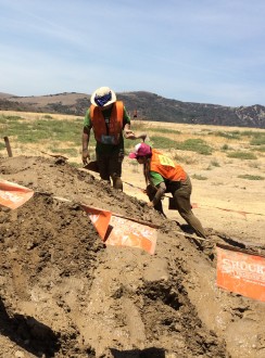Aurora De Lucia being guided up a little muddy hill during the Irvine Lake Summer of Mud run 2014