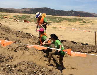 Aurora getting pulled out of mud by her guides at the Irvine Lake Obstacle Course Mud Run 2014