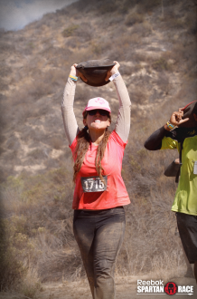 Aurora De Lucia carrying a sandbag over her head at the Spartan Beast Race in Temecula