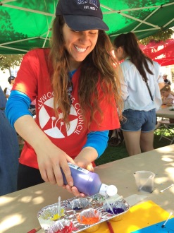 Aurora De Lucia smiling while pouring paint into cups at the Hollywood Arts Council Festival of the Arts