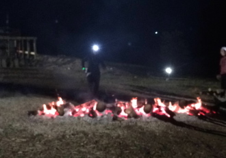 Aurora in the dark about to jump over some fire at the Spartan trifecta-in-a-day 2014