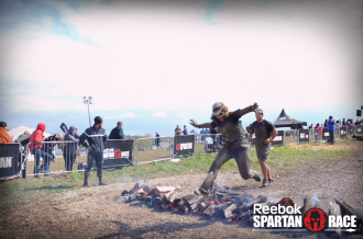Aurora jumping over fire at the end of the Beast at Spartan Ohio trifecta-in-a-day 2014