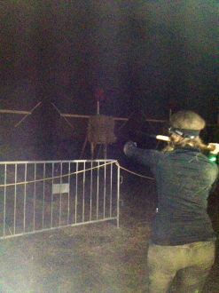 Aurora, at night, with her back to the camera, aiming at the Spear Throw at the Spartan Ohio trifecta-in-a-day 2014
