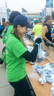 Aurora unwrapping medals at the Long Beach 5k
