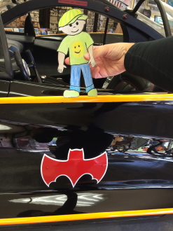 Flat Stanley standing by the Batmobile