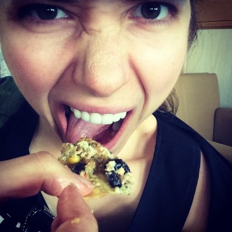 Aurora De Lucia messily eating a nacho full of vegan toppings
