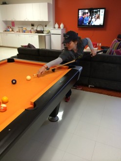 Aurora De Lucia playing pool in the break room at work