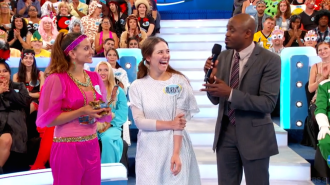 Aurora De Lucia with Sharmine, Let's Make a Deal Contestants, stand smiling, interested, looking at Wayne Brady