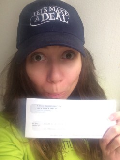 Aurora De Lucia wears her Let's Make a Deal hat and holds up her check from her zonk