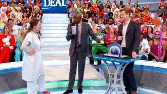 Aurora De Lucia with her hands on her hips looking at Wayne Brady & Jonathan Mangum during Let's Make a Deal