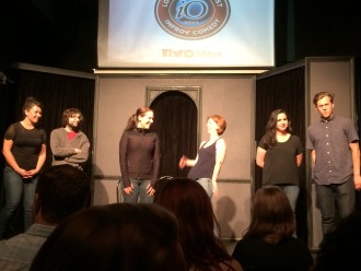 Aurora and partner laughing in the center of the stage during improv with The Deltones at iO West
