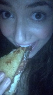 Aurora eating grilled cheese in the dark
