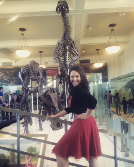 aurora smiling in front of a dinosaur at the AMNH filtered