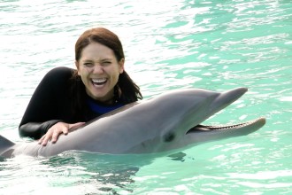 Aurora giving a big smile while holding her dolphin friend