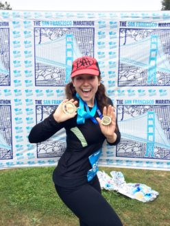 Aurora DeLucia posing with her medals at the end of the San Fran 1st half marathon