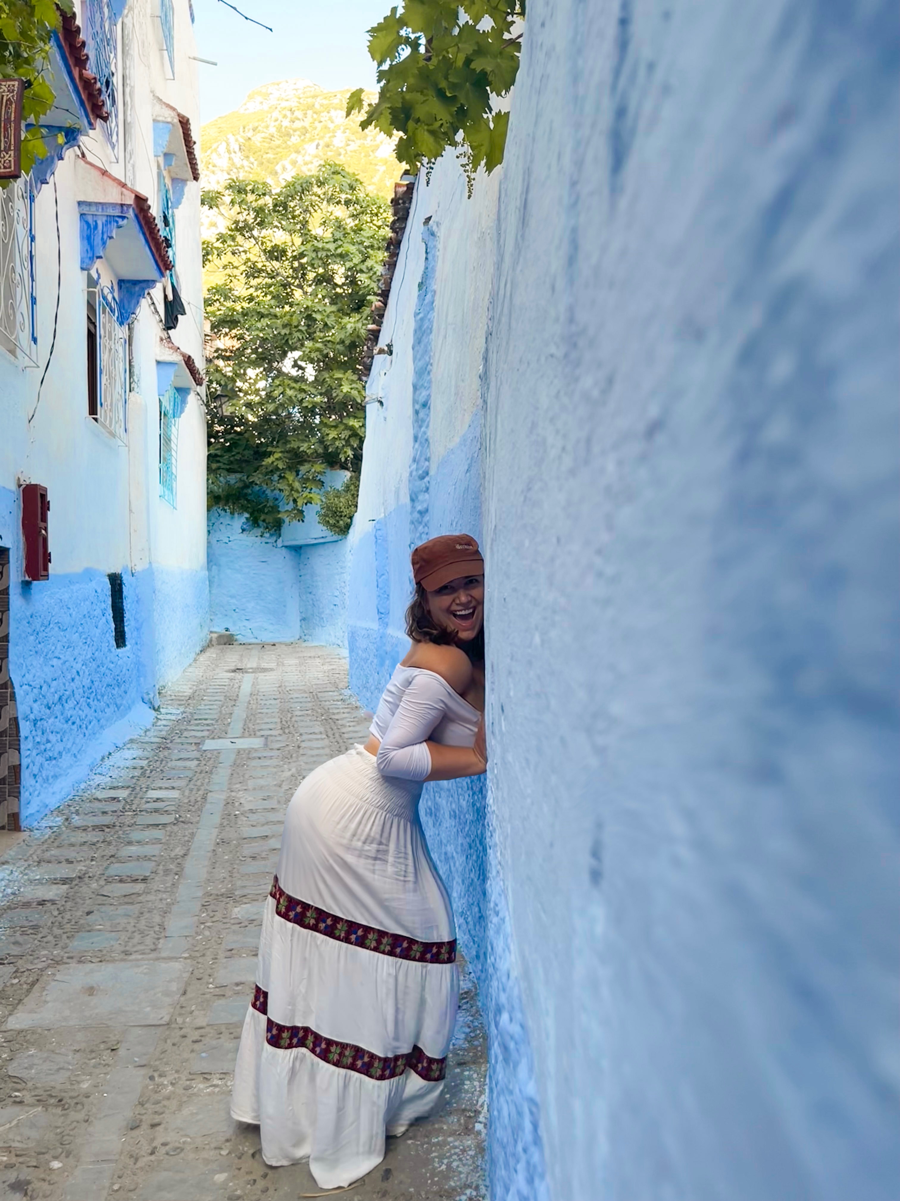 Aurora-De-Lucia-leaning-into-a-blue-wall-in-The-Blue-City